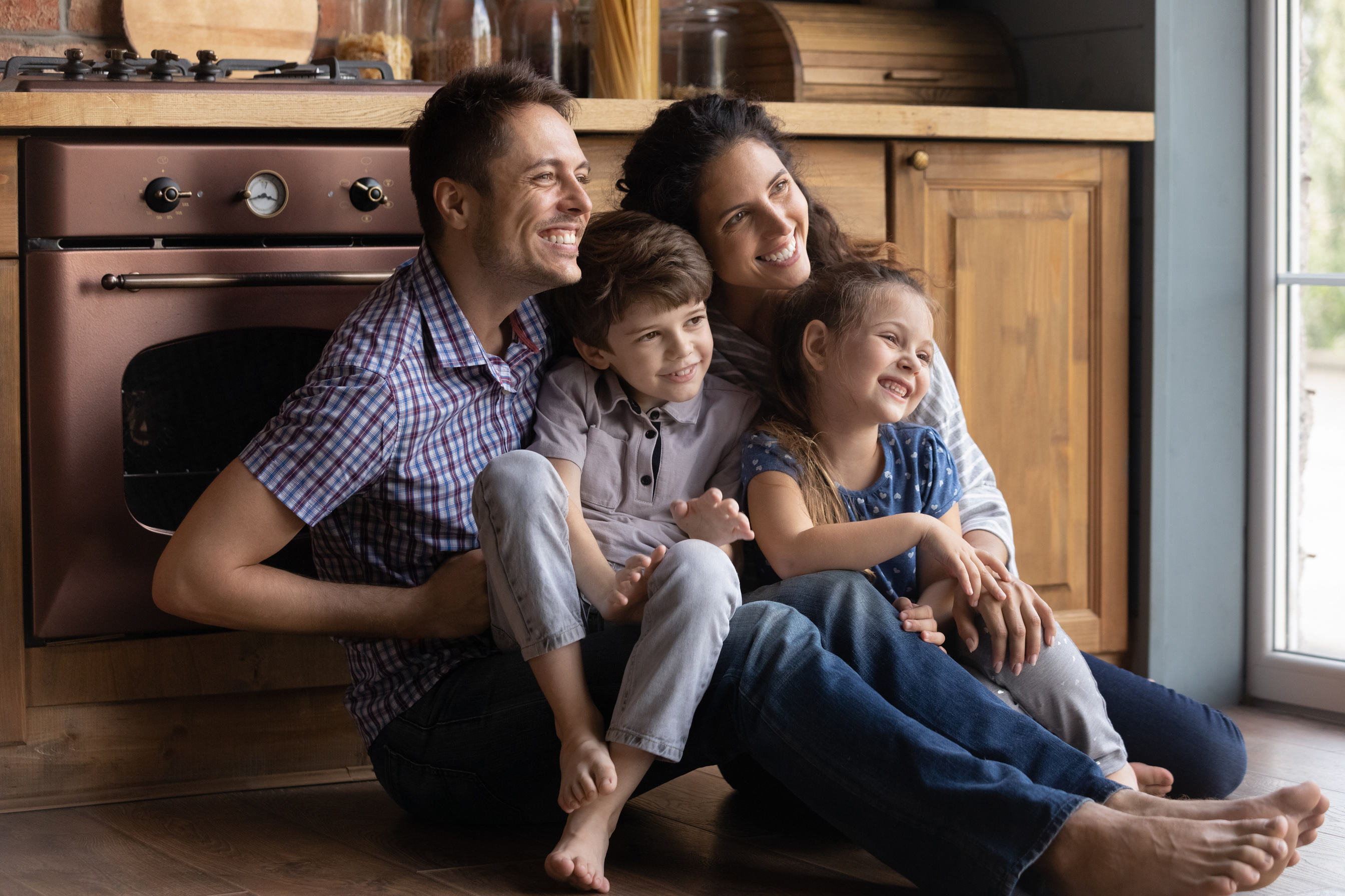 Family Sitting on the Floor of Kitchen at Home