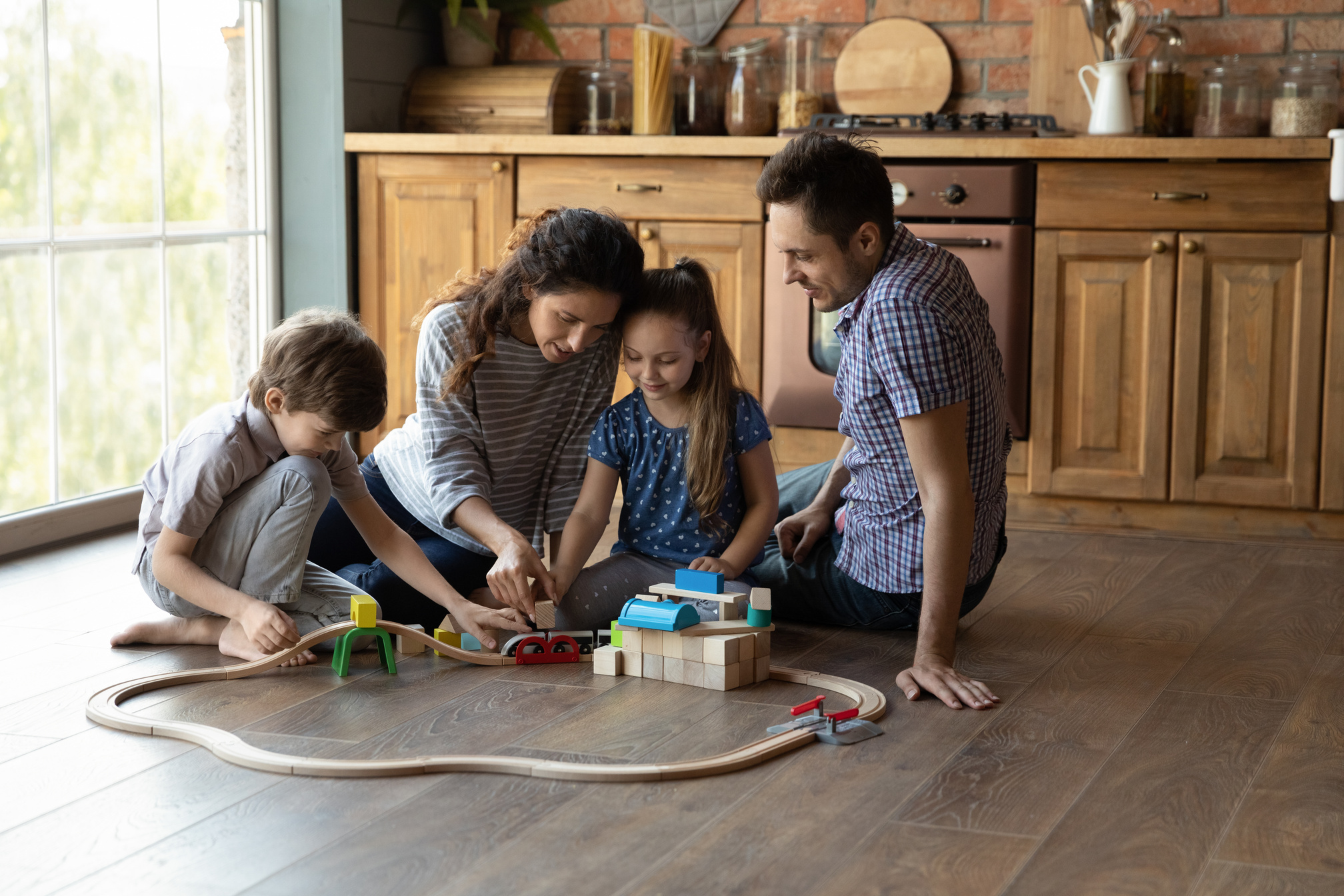 Happy Family Playing with Toys While Sitting on the Floor