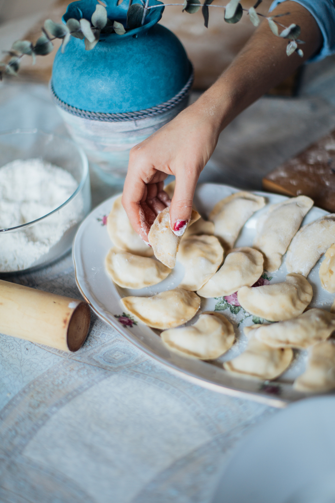 Person Putting Pelmeni in White Ceramic Plate